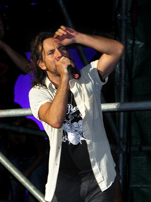 Eddie Vedder singing into a microphone on stage